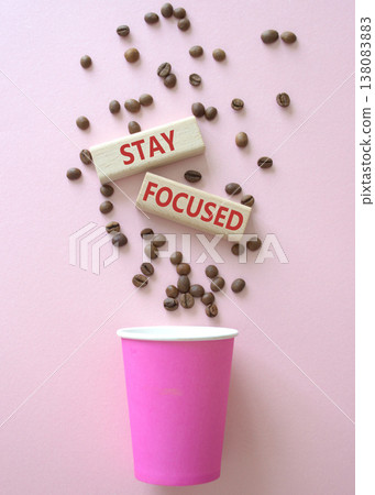 Stay Focused symbol. Concept word Stay Focused on wooden blocks. Beautiful pink background with coffee cup. Business and Stay Focused concept. Copy space 138083883