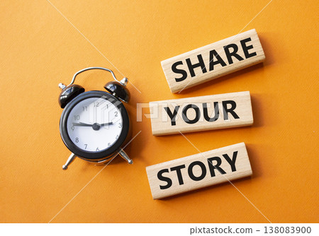 Share your story symbol. Wooden blocks with words Share your story. Beautiful orange background with alarm clock. Business and Share your story concept. Copy space. 138083900