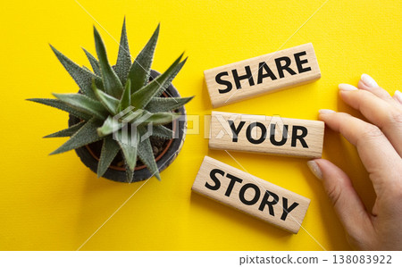 Share your story symbol. Wooden blocks with words Share your story. Beautiful yellow background with succulent plant. Businessman hand. Business and Share your story concept. Copy space. 138083922