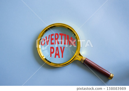 Overtime Pay symbol. Magnifying Glass with words Overtime Pay. Beautiful blue background. Business and Overtime Pay concept. Copy space. 138083989