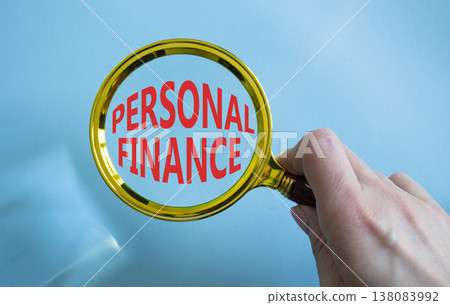 Personal Finance symbol. Magnifying Glass with words Personal Finance. Businessman hand. Beautiful blue background. Business and Personal Finance concept. Copy space. 138083992