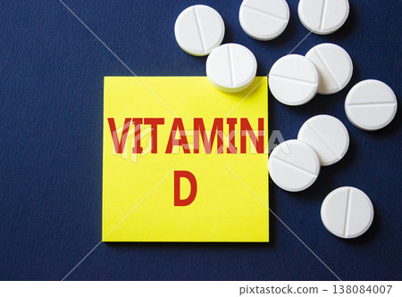 Vitamin D symbol. Concept word Vitamin D on yellow note. Beautiful deep blue background with pills. Medicine and Vitamin D concept. Copy space 138084007