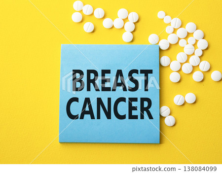 Breast cancer symbol. Concept word Breast cancer on blue note. Beautiful yellow background with pills. Medicine and Breast cancer concept. Copy space 138084099