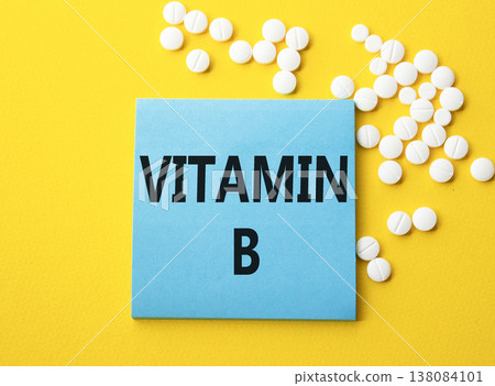 Vitamin B symbol. Concept word Vitamin B on blue note. Beautiful yellow background with pills. Medicine and Vitamin B concept. Copy space Vitamin B symbol. Concept word Vitamin B on blue note. Beautiful yellow background with pills. Medicine and Vitamin B concept. Copy space 138084101