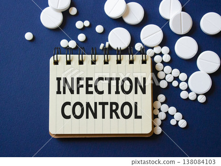Infection Control symbol. Concept word Infection Control on notebook. Beautiful deep blue background with pills. Medicine and Infection Control concept. Copy space 138084103