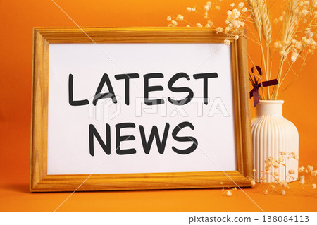 Latest News symbol. Concept words Latest News on beautiful wooden picture frame. Beautiful orange background with flower vase. Business and Latest News concept. Copy space. Latest News symbol. Concept words Latest News on beautiful wooden picture frame. Beautiful orange background with flower vase. Business and Latest News concept. Copy space. 138084113