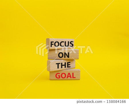 GOAL symbol. Wooden blocks with words FOCUS ON THE GOAL. Beautiful yellow background. Business and GOAL concept. Copy space 138084166