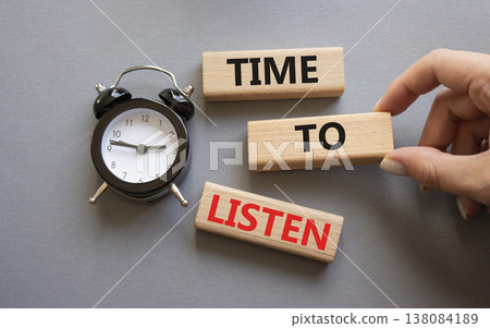 Time to listen symbol. Concept words Time to listen on wooden blocks. Businessman hand. Beautiful grey background with alarm clock. Business and Time to listen concept. Copy space. 138084189