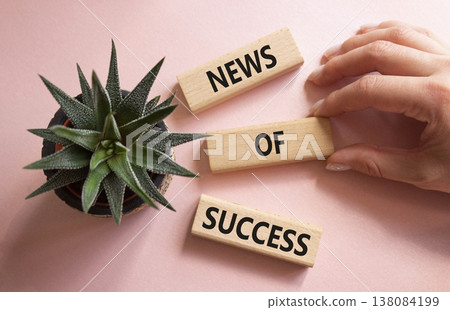 News of Success symbol. Concept words News of Success on wooden blocks. Beautiful pink background with succulent plant. Businessman hand. Business and News of Success concept. Copy space. News of Success symbol. Concept words News of Success on wooden blocks. Beautiful pink background with succulent plant. Businessman hand. Business and News of Success concept. Copy space. 138084199