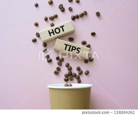 Hot Tips symbol. Concept word Hot Tips on wooden blocks. Beautiful pink background with coffee cup. Business and Hot Tips concept. Copy space Hot Tips symbol. Concept word Hot Tips on wooden blocks. Beautiful pink background with coffee cup. Business and Hot Tips concept. Copy space 138084262