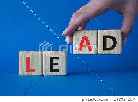 Lead symbol. Concept word Lead on wooden cubes. Businessman hand. Beautiful blue background. Business and Lead concept. Copy space. Lead symbol. Concept word Lead on wooden cubes. Businessman hand. Beautiful blue background. Business and Lead concept. Copy space. 138084297