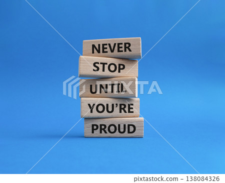 Never Stop symbol. Wooden blocks with words Never Stop Until You are Proud. Beautiful blue background. Business and Never Stop concept. Copy space 138084326