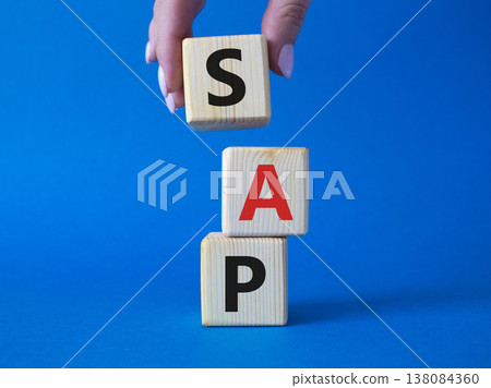 SAP - Systems Applications Products. Wooden cubes with word SAP . Businessman hand. Beautiful blue background. Business and System Application Product concept. Copy space. SAP - Systems Applications Products. Wooden cubes with word SAP . Businessman hand. Beautiful blue background. Business and System Application Product concept. Copy space. 138084360