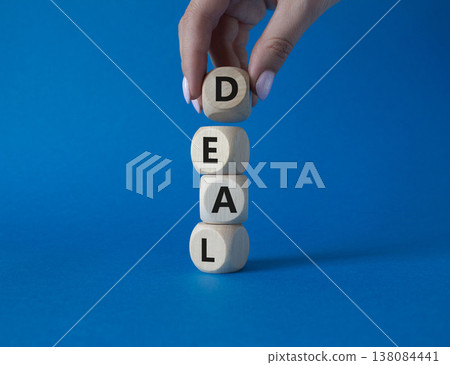 Deal symbol. Concept word Deal on wooden cubes. Businessman hand. Beautiful blue background. Business and Deal concept. Copy space. Deal symbol. Concept word Deal on wooden cubes. Businessman hand. Beautiful blue background. Business and Deal concept. Copy space. 138084441