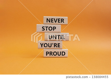 Never Stop symbol. Wooden blocks with words Never Stop Until You are Proud. Beautiful orange background. Business and Never Stop concept. Copy space 138084455