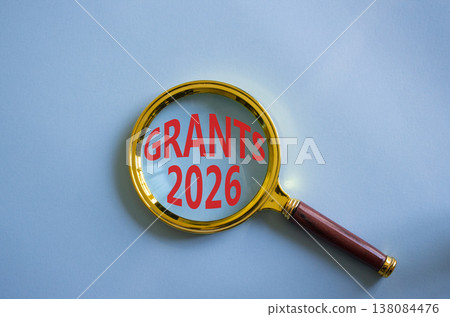Grants 2026 symbol. Magnifying Glass with words Grants 2026. Beautiful blue background. Business and Grants 2026 concept. Copy space. 138084476