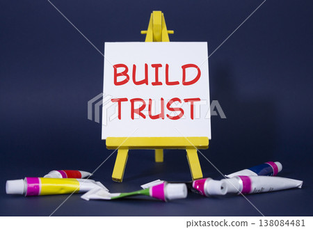 Build trust symbol. Wooden blocks with words Build trust. Beautiful deep blue background with paints and easel. Business and Build trust concept. Copy space. 138084481