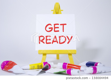 Get ready symbol. Wooden blocks with words Get ready. Beautiful white background with paints and easel. Business and Get ready concept. Copy space. 138084494