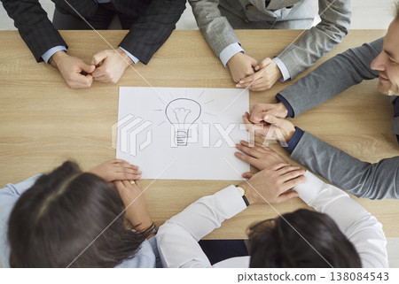 Team of people developing new creative business idea at table with lightbulb drawing 138084543