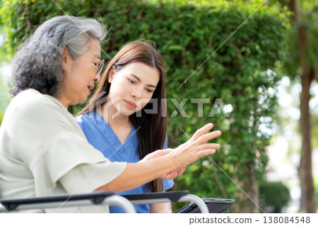 Female caregiver using digital tablet for senior patient consultation. Female caregiver using digital tablet for senior patient consultation. 138084548