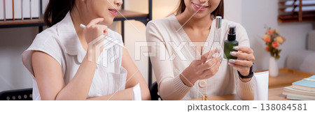 Two asian businesswoman testing and researching cosmetic product or cream in bottle in office. Two asian businesswoman testing and researching cosmetic product or cream in bottle in office. 138084581