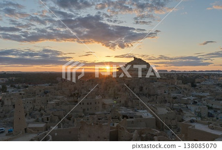The Shari ruins and the old city of Siwa bathed in the backlight of the setting sun. The Shari ruins and the old city of Siwa bathed in the backlight of the setting sun. 138085070