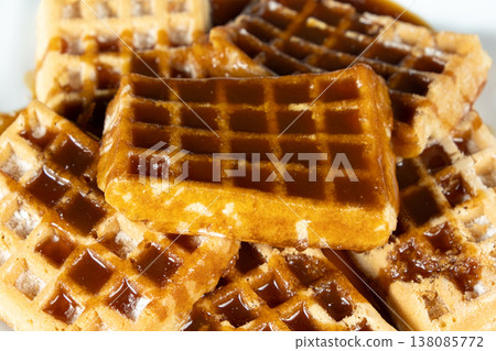 Delicious Belgian waffles topped with sweet caramel syrup close up. 138085772