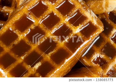 Sweet dessert background with waffles and flowing caramel syrup. 138085773