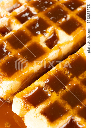Sweet dessert background with waffles and flowing caramel syrup. Sweet dessert background with waffles and flowing caramel syrup. 138085778