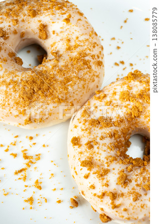 Two glazed donuts with crunchy topping on white background Two glazed donuts with crunchy topping on white background 138085779