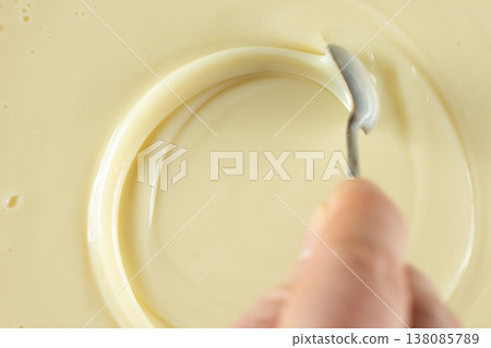 Spoon in a swirl of sweet condensed milk. 138085789