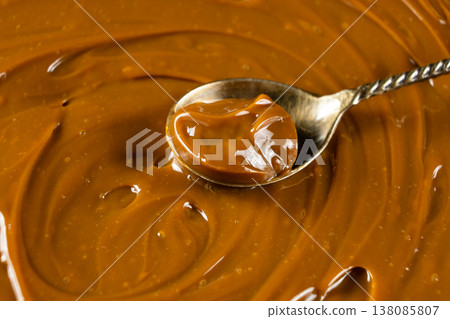 Dulce de leche on a spoon, thick boiled condensed milk Dulce de leche on a spoon, thick boiled condensed milk 138085807