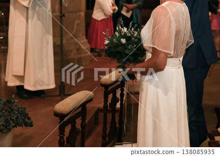 Bride and groom and priest stand at church altar during solemn ceremony Bride and groom and priest stand at church altar during solemn ceremony 138085935