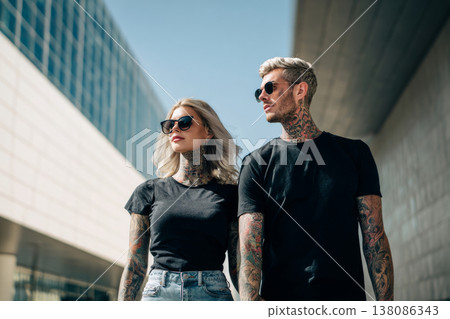 fashionable tattooed couple walking confidently in downtown district, modern architecture 138086343