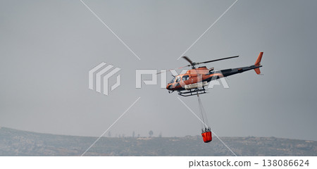 Helicopter in Action with Firefighting Bucket 138086624