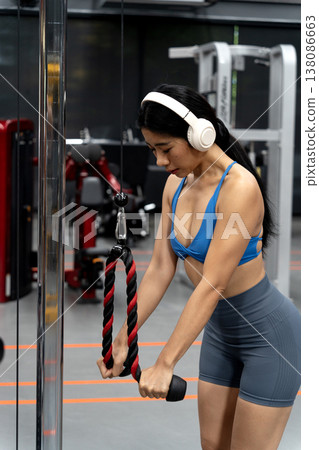 Young asian woman is standing and exercising on a standing exercise machine Young asian woman is standing and exercising on a standing exercise machine 138086663