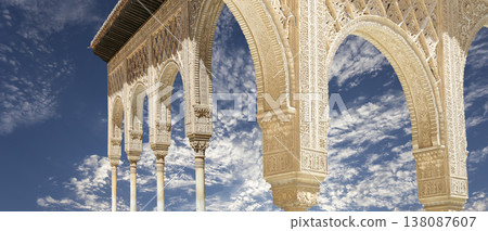 Arches in Islamic (Moorish) style (against the background of a beautiful sky with clouds) in Alhambra, Granada, Spain Arches in Islamic (Moorish) style (against the background of a beautiful sky with clouds) in Alhambra, Granada, Spain 138087607