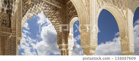 Arches in Islamic (Moorish) style (against the background of a beautiful sky with clouds) in Alhambra, Granada, Spain Arches in Islamic (Moorish) style (against the background of a beautiful sky with clouds) in Alhambra, Granada, Spain 138087609