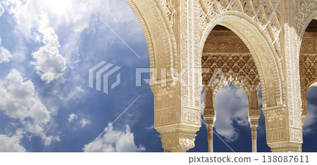 Arches in Islamic (Moorish) style (against the background of a beautiful sky with clouds) in Alhambra, Granada, Spain Arches in Islamic (Moorish) style (against the background of a beautiful sky with clouds) in Alhambra, Granada, Spain 138087611