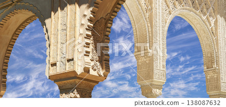 Arches in Islamic (Moorish) style (against the background of a beautiful sky with clouds) in Alhambra, Granada, Spain Arches in Islamic (Moorish) style (against the background of a beautiful sky with clouds) in Alhambra, Granada, Spain 138087632