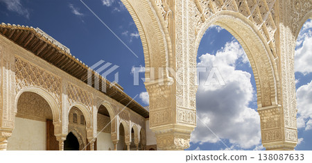 Arches in Islamic (Moorish) style (against the background of a beautiful sky with clouds) in Alhambra, Granada, Spain Arches in Islamic (Moorish) style (against the background of a beautiful sky with clouds) in Alhambra, Granada, Spain 138087633