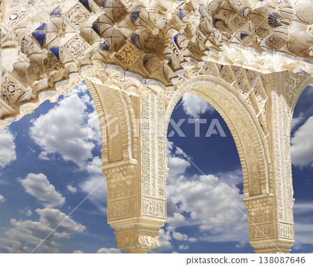 Arches in Islamic (Moorish) style (against the background of a beautiful sky with clouds) in Alhambra, Granada, Spain Arches in Islamic (Moorish) style (against the background of a beautiful sky with clouds) in Alhambra, Granada, Spain 138087646