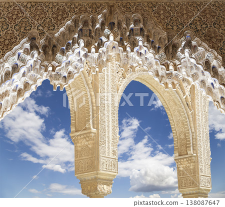 Arches in Islamic (Moorish) style (against the background of a beautiful sky with clouds) in Alhambra, Granada, Spain 138087647