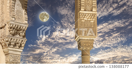 Arches in Islamic (Moorish) style (against the background of a beautiful evening sky with clouds with the super moon) in Alhambra, Granada, Spain Arches in Islamic (Moorish) style (against the background of a beautiful evening sky with clouds with the super moon) in Alhambra, Granada, Spain 138088177