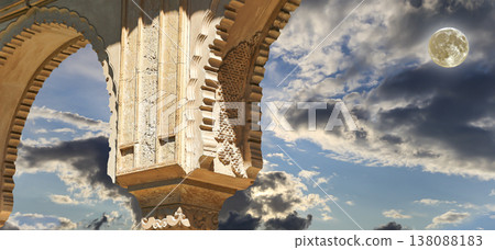 Arches in Islamic (Moorish) style (against the background of a beautiful evening sky with clouds with the super moon) in Alhambra, Granada, Spain Arches in Islamic (Moorish) style (against the background of a beautiful evening sky with clouds with the super moon) in Alhambra, Granada, Spain 138088183