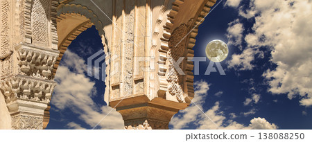 Arches in Islamic (Moorish) style (against the background of a beautiful evening sky with clouds with the super moon) in Alhambra, Granada, Spain 138088250