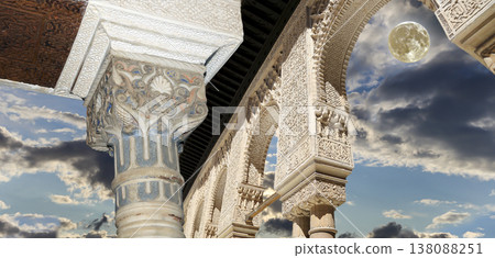 Arches in Islamic (Moorish) style (against the background of a beautiful evening sky with clouds with the super moon) in Alhambra, Granada, Spain 138088251