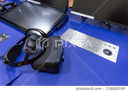 Virtual reality headset rests beside computer monitors Virtual reality headset rests beside computer monitors 138088399