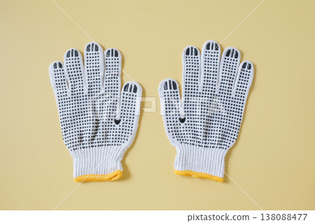 white knitted work gloves on color background. white knitted work gloves on color background. 138088477