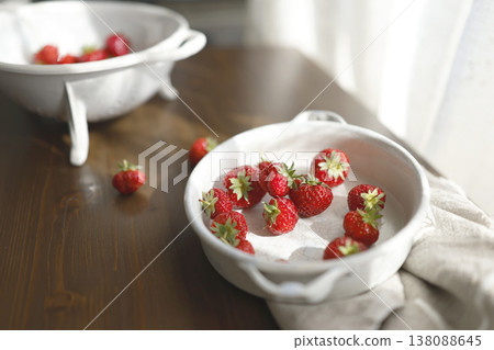 Fresh red strawberries in white ceramic vintage bowl on dark wooden table. Aesthetic food photography showcases organic summer berries for slow living breakfast and cottagecore kitchen vibes. 138088645